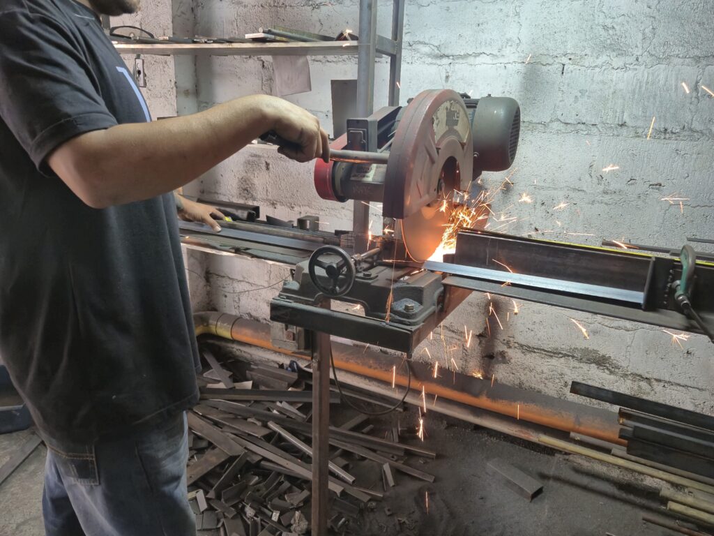 Corte de un perfil metálico con una cortadora de disco en el taller de INOR.