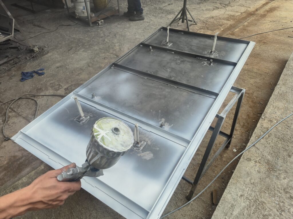 Aplicación de pintura sobre una pieza metálica en el taller de INOR.
